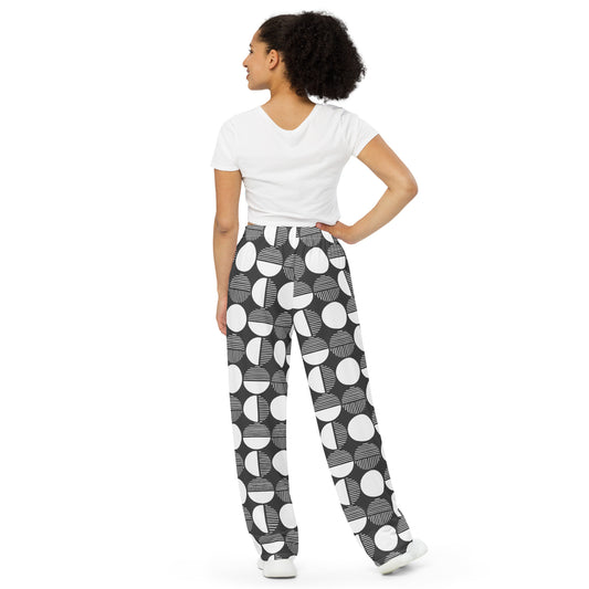 Woman wearing a white top and black and white patterned pants on a white background