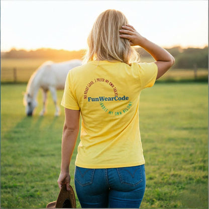 Person wearing a yellow t-shirt with Funwearcode branding in a field with a horse.