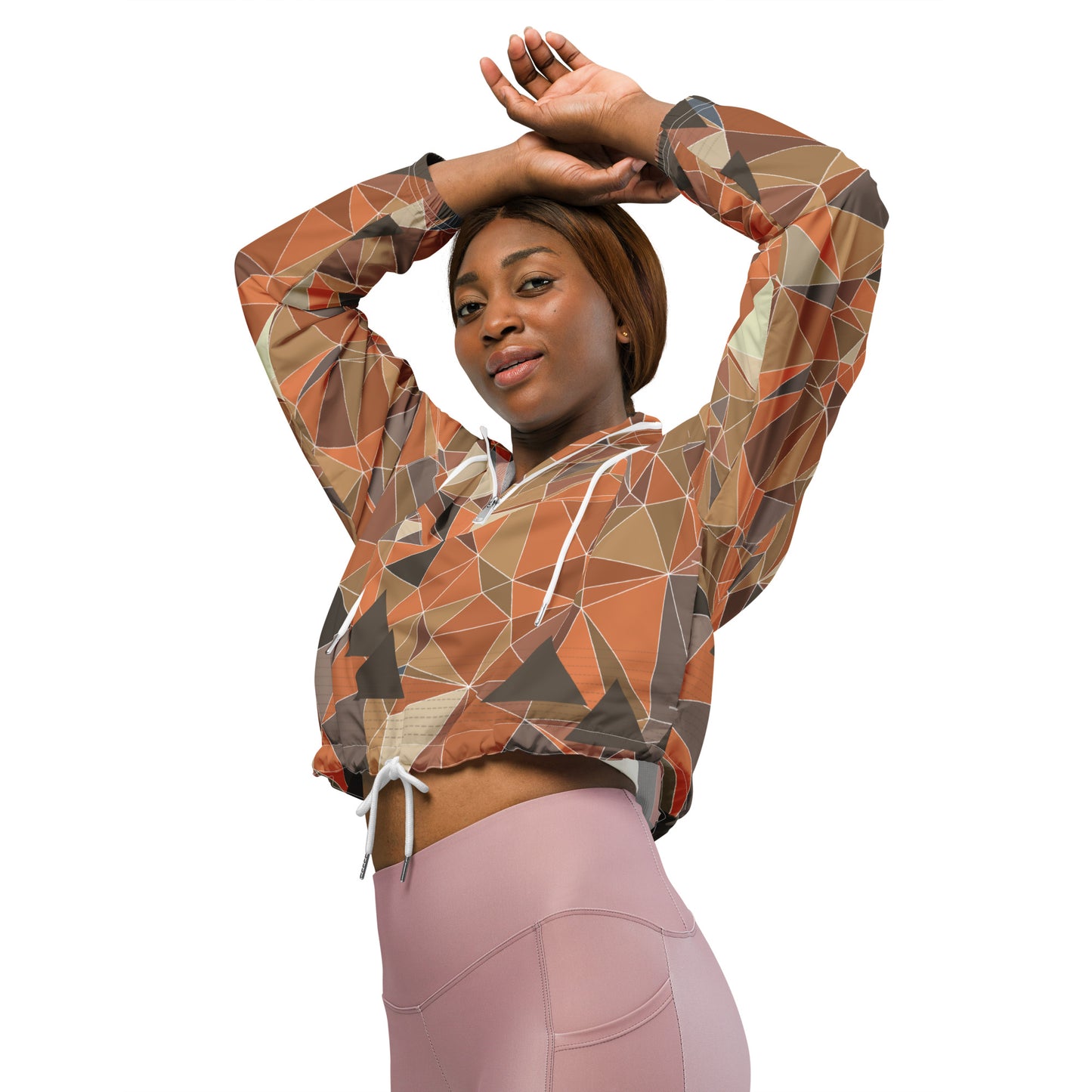 Woman wearing a geometric patterned crop top and pink leggings on a white background