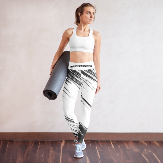 Woman holding a yoga mat wearing a white sports bra and black and white leggings with a brand logo 'Funwearcode'.