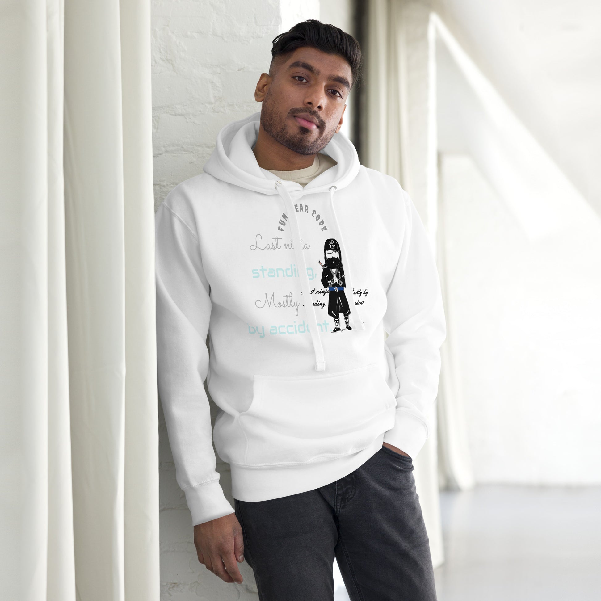 Person wearing a white hoodie with text and graphic design, standing against a light-colored wall.