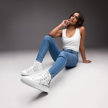 Woman sitting on a gray surface wearing white sneakers with a ninja graphic and 'Fun Wear Code' text logo, blue jeans, and a white tank top.